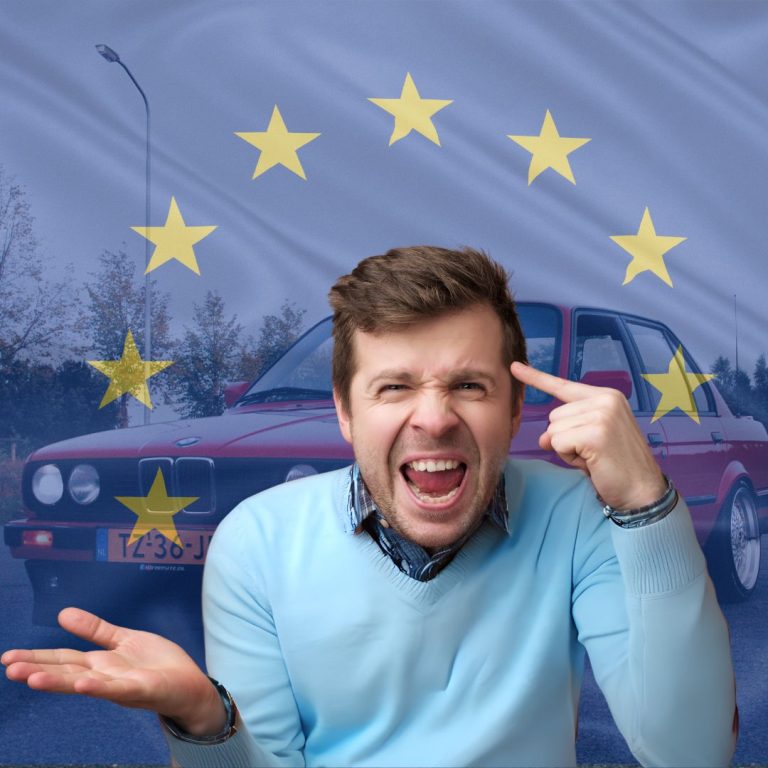 Un hombre expresando frustración con gestos y expresión facial delante de una bandera de la Unión Europea con estrellas brillantes, con un coche antiguo en el fondo, simbolizando el conflicto sobre la propuesta de prohibición de reparación de vehículos antiguos.